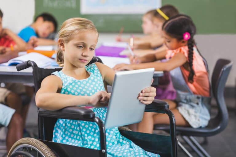 Disabled schoolgirl using digital tablet
