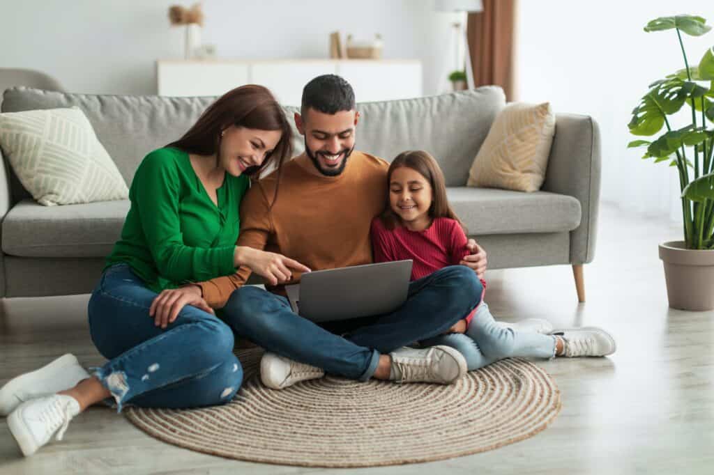 Happy Arab family using laptop in living room